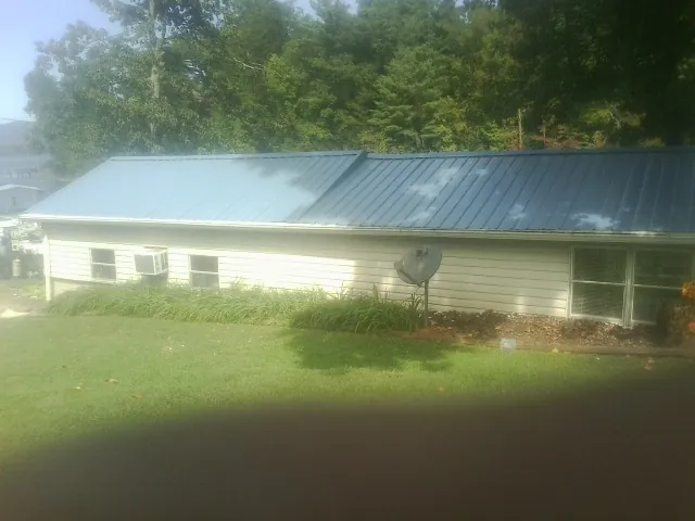 Blue metal roof running the length of a single story home in Jemison
