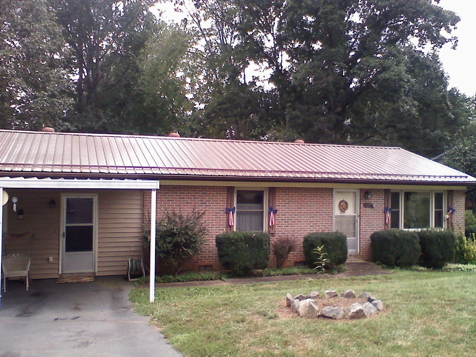 Bronze metal roof and carport on a brick ranch home — Roof Repair work by our crew in Jemison