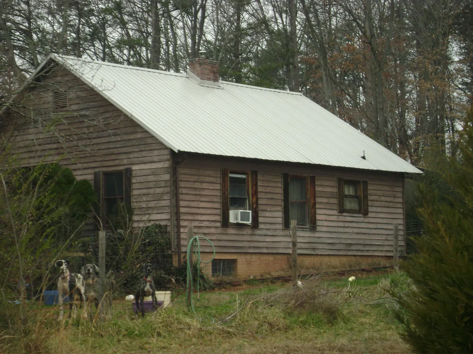 White metal roof on an old wood sided farmhouse, from a Metal Roof Installation job in Jemison